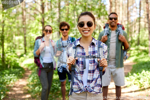 Image of friends with backpacks on hike in forest