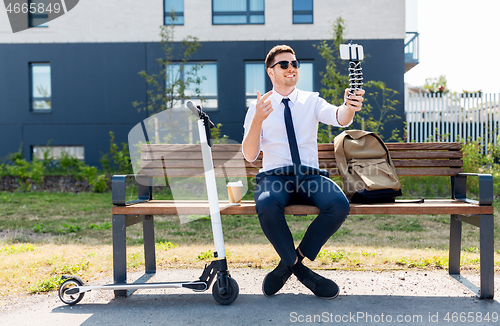 Image of businessman recording video blog by smartphone