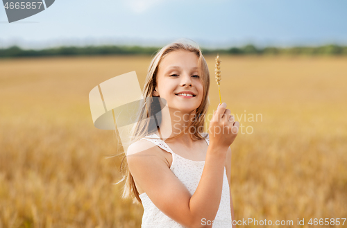 Image of girl with spikelet of wheat on cereal field