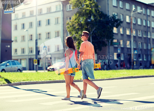 Image of teenage couple with skateboards on city crosswalk