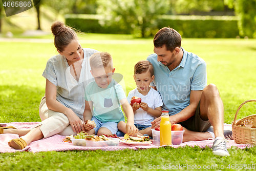 Image of happy family having picnic at summer park