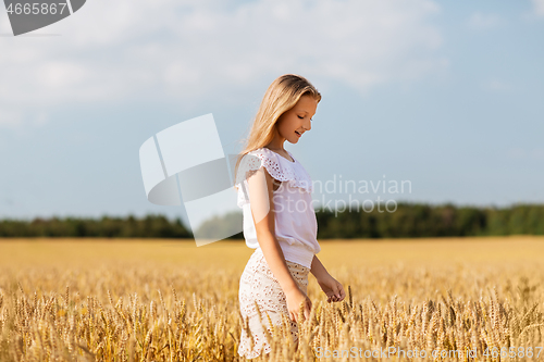 Image of smiling young girl on cereal field in summer