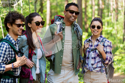 Image of group of friends with backpacks hiking in forest