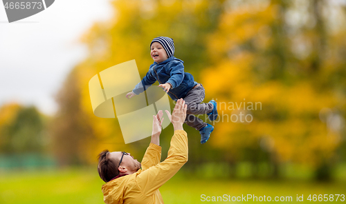 Image of father with son playing and having fun in autumn