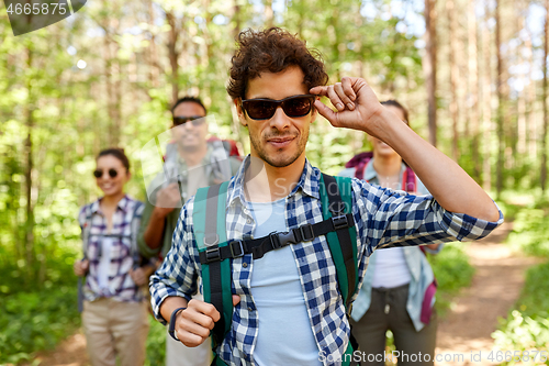 Image of friends with backpacks on hike in forest