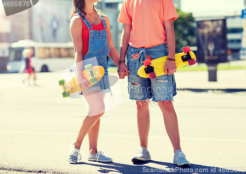 Image of close up of young couple with skateboards in city