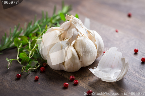 Image of Garlic with red pepper and herbs on wooden background