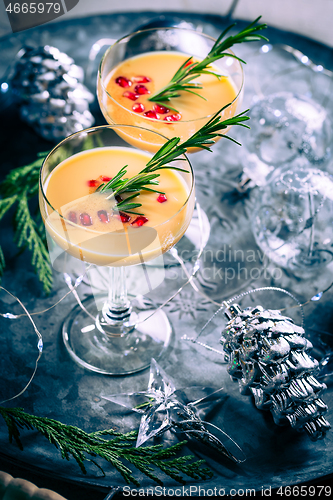 Image of Traditional egg liqueur or eggnog with cinnamon, pomegranate and rosemary for Christmas