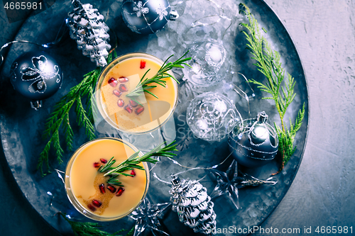 Image of Traditional egg liqueur or eggnog with cinnamon, pomegranate and rosemary for Christmas