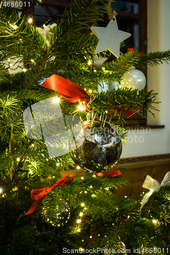 Image of Closeup of Christmas ball hanging from a decorated Christmas tree