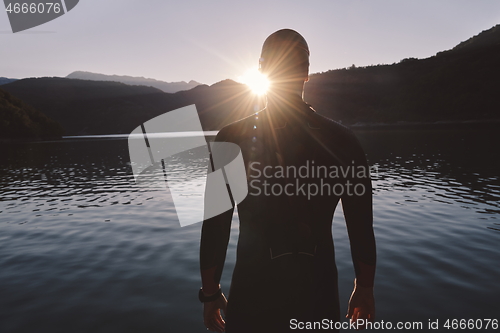 Image of triathlon athlete starting swimming training on lake