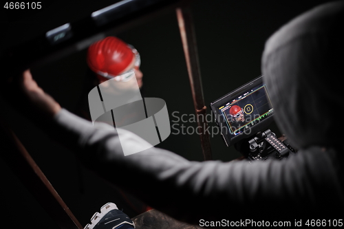 Image of videographer taking action shot of triathlon swimming athlete at night