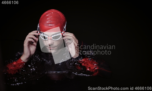 Image of authentic triathlete swimmer having a break during hard training on night