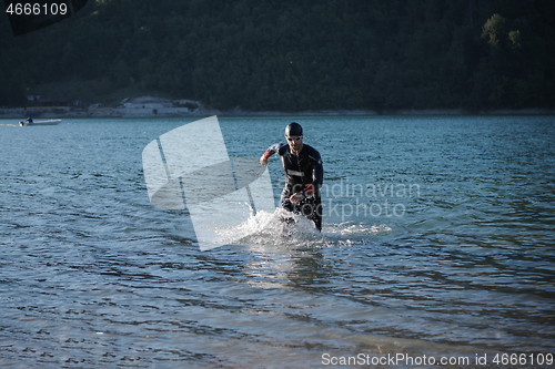 Image of triathlon athlete starting swimming training on lake