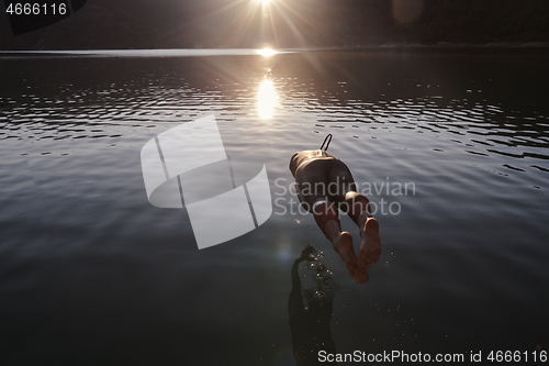 Image of triathlon athlete jumping in to water and starting with training