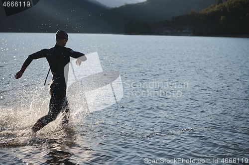 Image of triathlon athlete starting swimming training on lake