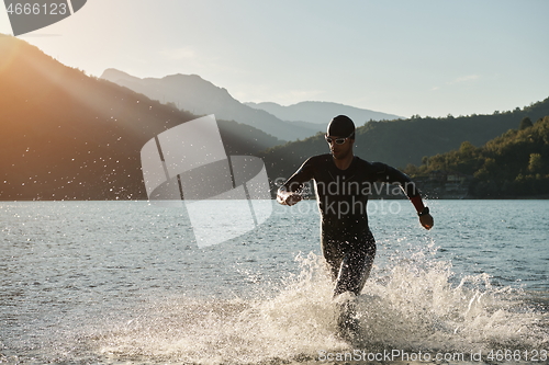 Image of triathlon athlete starting swimming training on lake