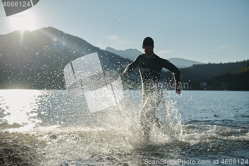 Image of triathlon athlete starting swimming training on lake