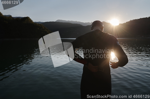 Image of triathlon athlete starting swimming training on lake