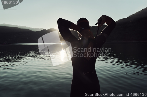 Image of triathlon athlete starting swimming training on lake