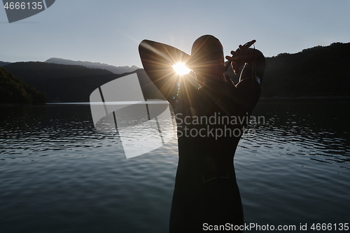 Image of triathlon athlete starting swimming training on lake