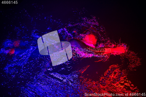 Image of real triathlon athlete swimming in dark night