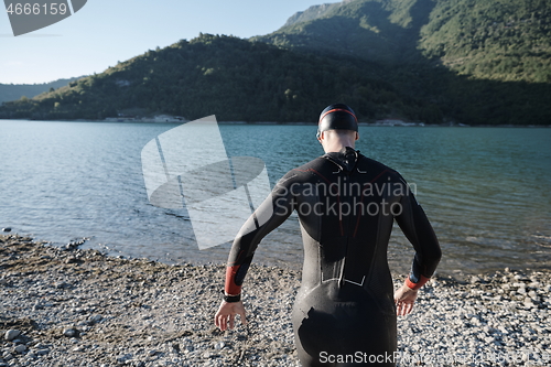 Image of triathlon athlete starting swimming training on lake