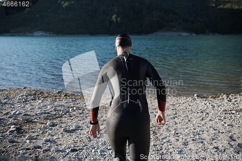 Image of triathlon athlete starting swimming training on lake