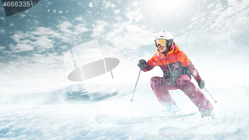 Image of Young woman and winter sport - she is skiing against white alps mountains