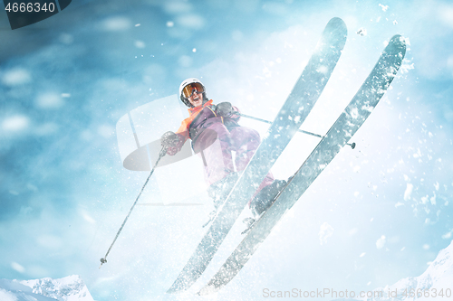 Image of Young woman and winter sport - she is skiing against white alps mountains