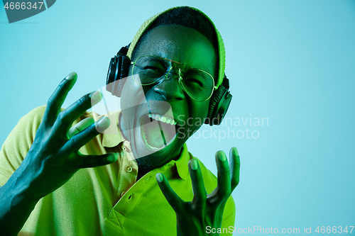 Image of The young handsome hipster man listening music with headphones