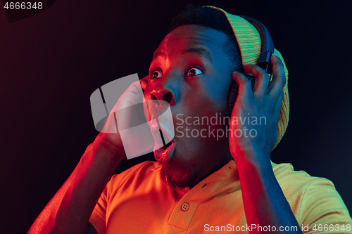 Image of The young handsome hipster man listening music with headphones