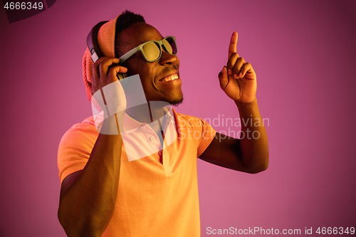 Image of The young handsome hipster man listening music with headphones