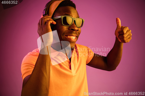 Image of The young handsome hipster man listening music with headphones