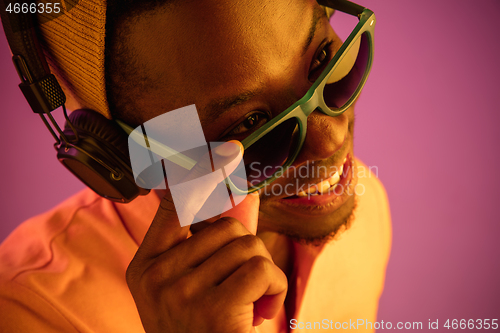 Image of The young handsome hipster man listening music with headphones