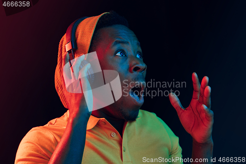 Image of The young handsome hipster man listening music with headphones