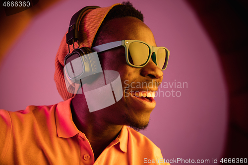 Image of The young handsome hipster man listening music with headphones