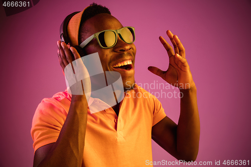 Image of The young handsome hipster man listening music with headphones