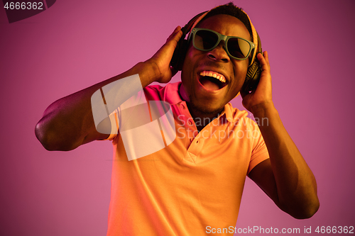 Image of The young handsome hipster man listening music with headphones