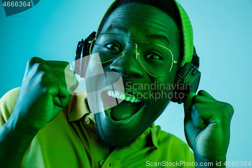 Image of The young handsome hipster man listening music with headphones