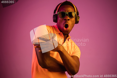 Image of The young handsome hipster man listening music with headphones