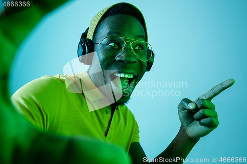 Image of The young handsome hipster man listening music with headphones