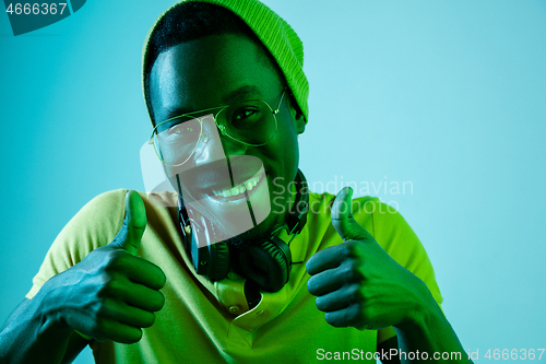 Image of The young handsome hipster man listening music with headphones