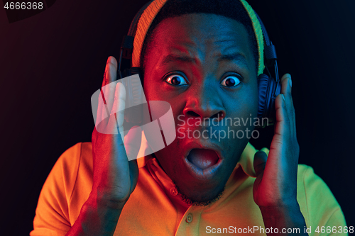 Image of The young handsome hipster man listening music with headphones