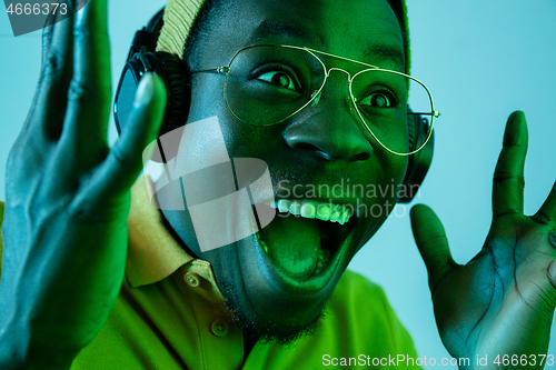 Image of The young handsome hipster man listening music with headphones