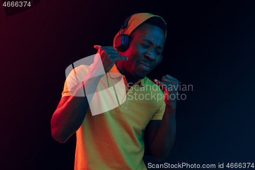 Image of The young handsome hipster man listening music with headphones