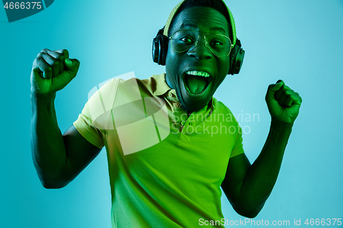 Image of The young handsome hipster man listening music with headphones