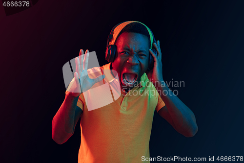 Image of The young handsome hipster man listening music with headphones