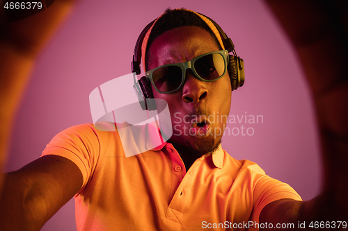 Image of The young handsome hipster man listening music with headphones