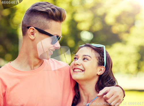 Image of happy teenage couple looking at each other in park